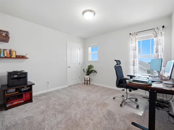 a view of a workspace with furniture and a window