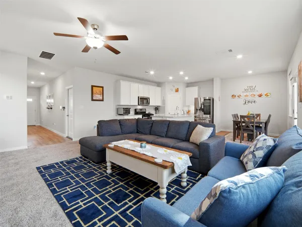 a kitchen with granite countertop kitchen island stainless steel appliances a refrigerator and a dining table