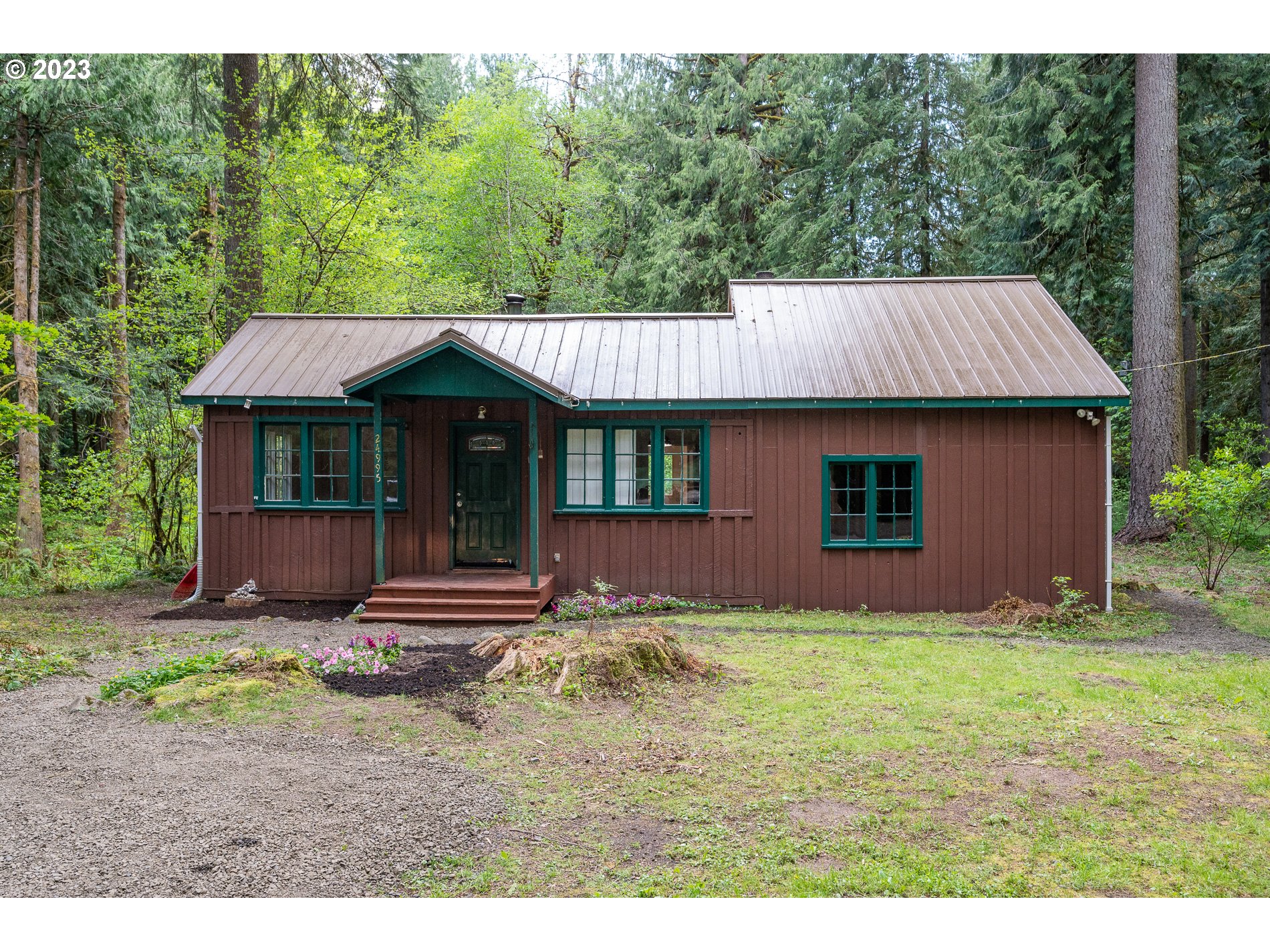 24995 East Old Smokey Road Rhododendron, OR 97049 - Photo 4 of 39 a front view of a house with a garden and yard