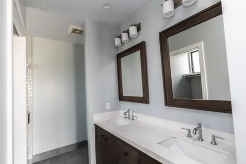 a bathroom with 2 sink and a mirror