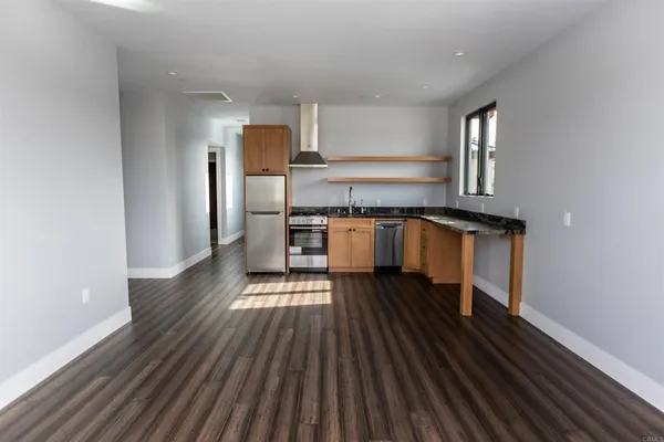 a kitchen with wooden floors and stainless steel appliances