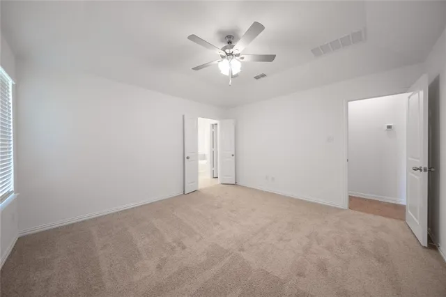 a view of an empty room with a ceiling fan
