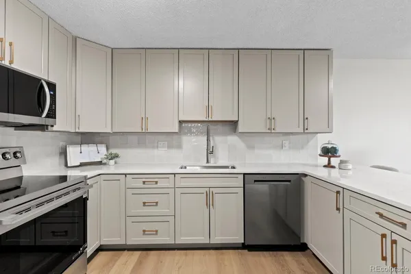 a kitchen with cabinets appliances a sink and a counter space