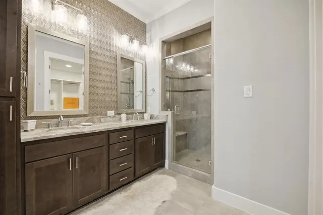 a bathroom with a double vanity sink and mirror with shower