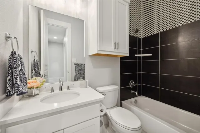 a bathroom with a sink toilet vanity and shower
