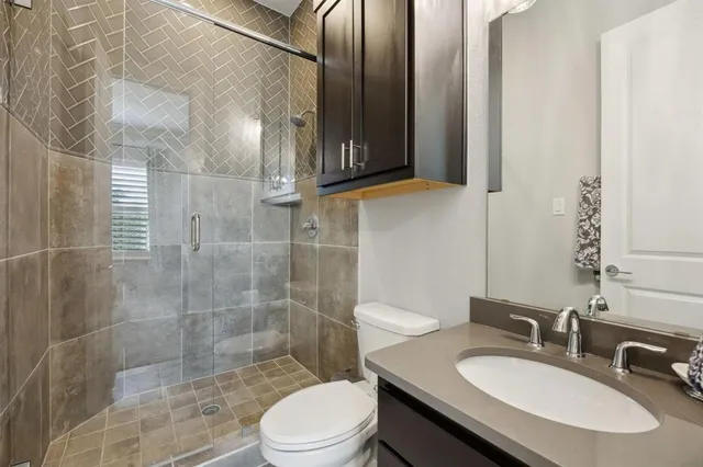 a bathroom with a sink a toilet and shower