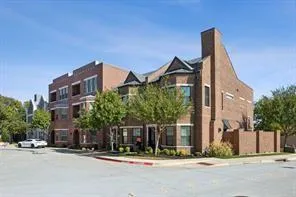 a front view of a building with a garden and plants