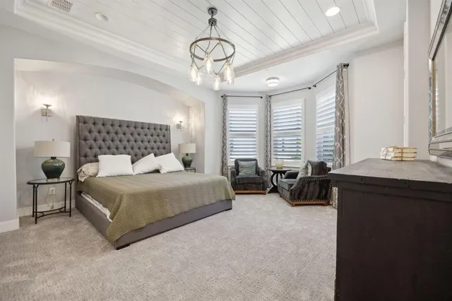 a bedroom with a bed a dresser and gym equipment