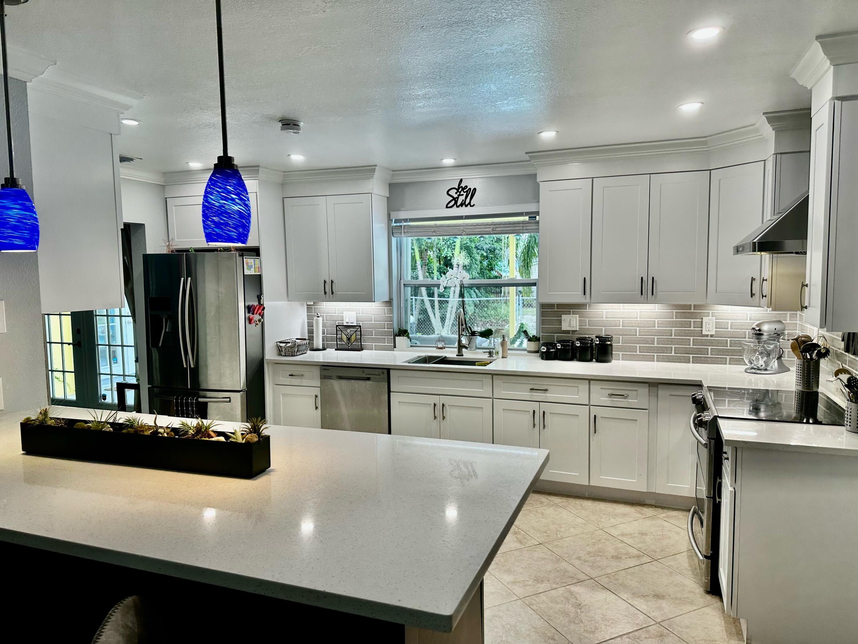 a kitchen with kitchen island granite countertop cabinets and refrigerator