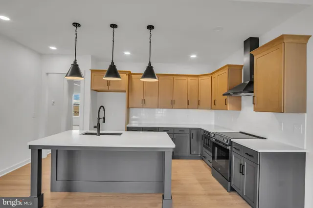 a kitchen with stainless steel appliances granite countertop a sink a stove and a wooden floors