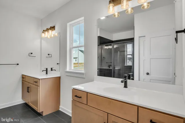 a bathroom with a sink and mirror with bathtub