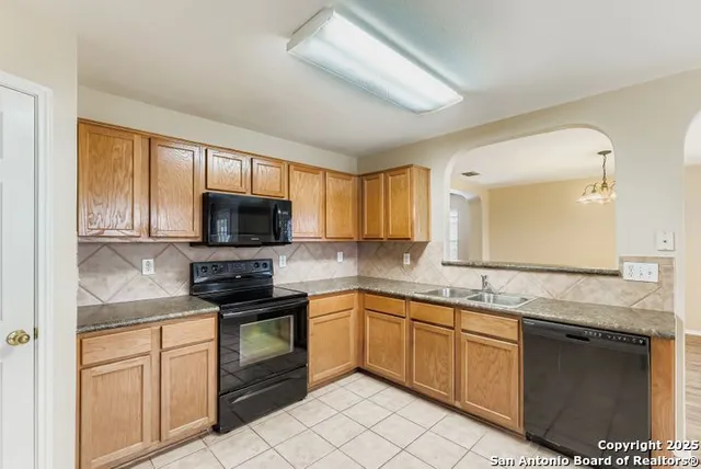 a kitchen with granite countertop a sink stainless steel appliances and cabinets