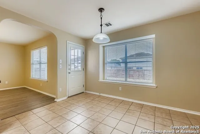 an empty room with windows and chandelier