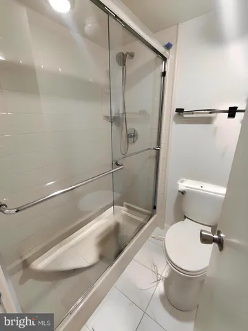 a white toilet sitting next to a bath tub