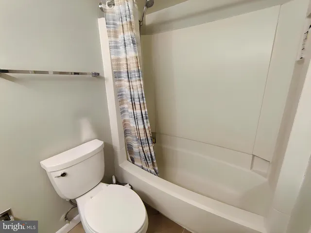 a white toilet sitting next to a bath tub