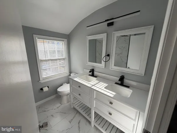 a bathroom with a sink a toilet and mirror