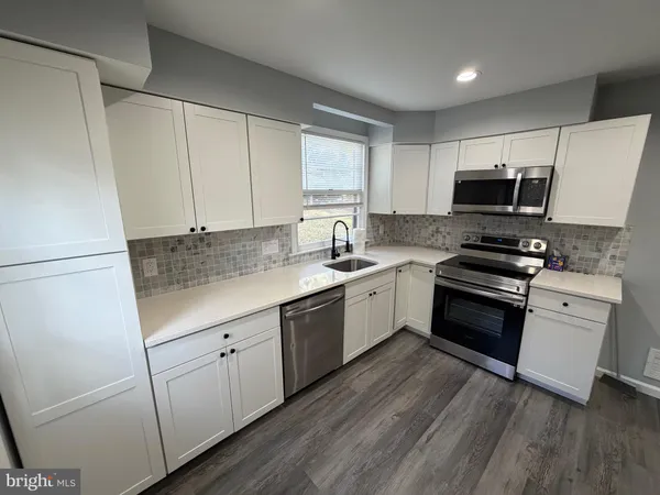 a kitchen with granite countertop white cabinets and white appliances