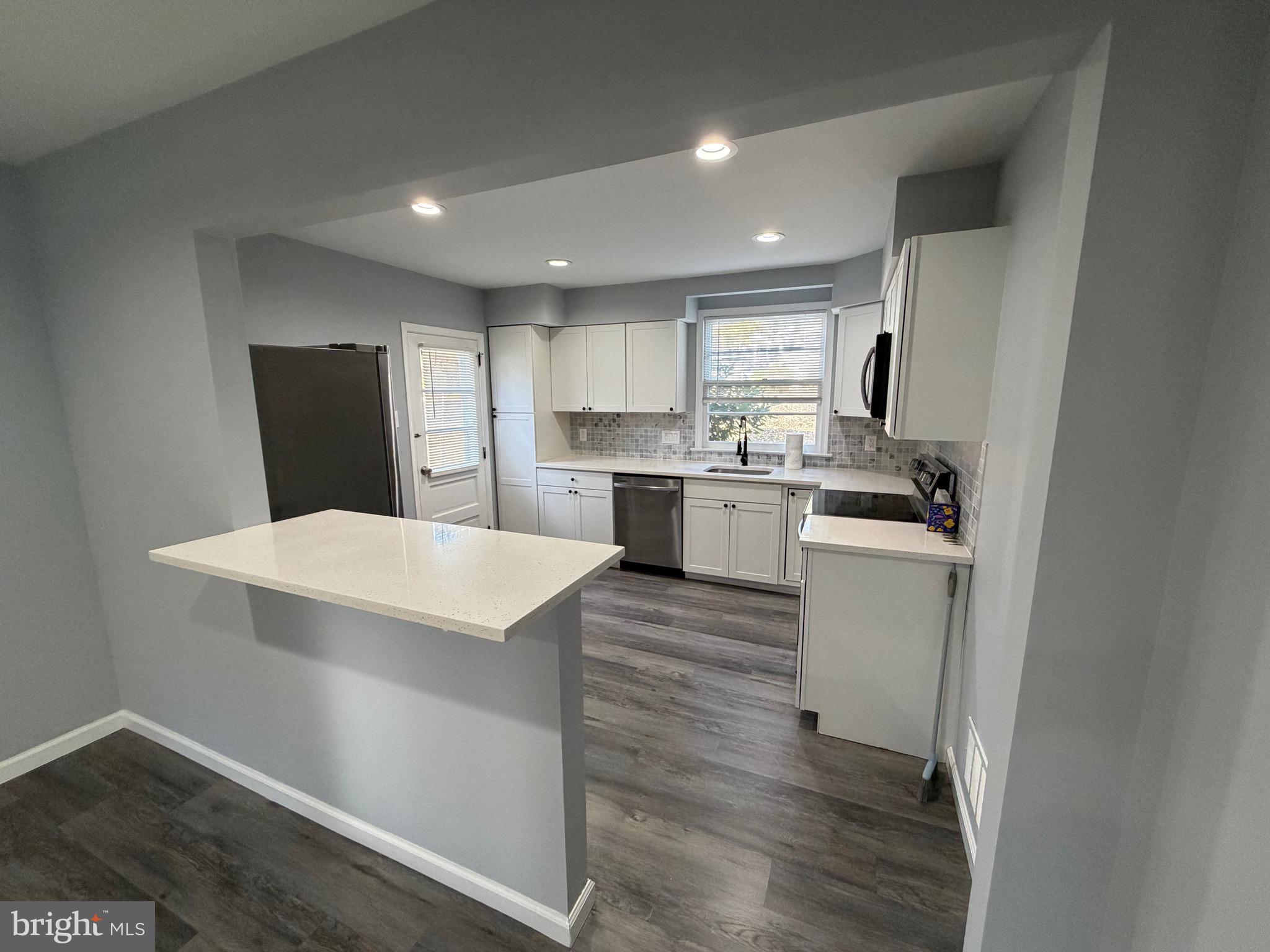 687 Bristol Road Southampton, PA 18966 - Photo 4 of 22 a kitchen with a refrigerator a sink dishwasher with a dining table and chairs