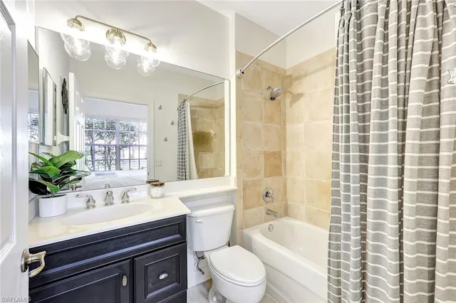 a bathroom with a sink a toilet a mirror a vanity and shower