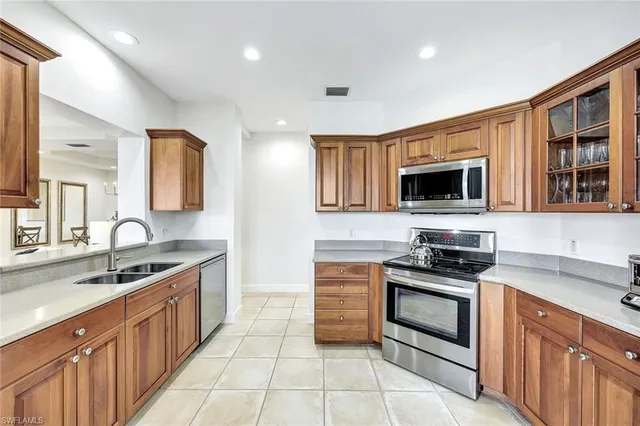 a kitchen with stainless steel appliances a stove sink microwave and cabinets