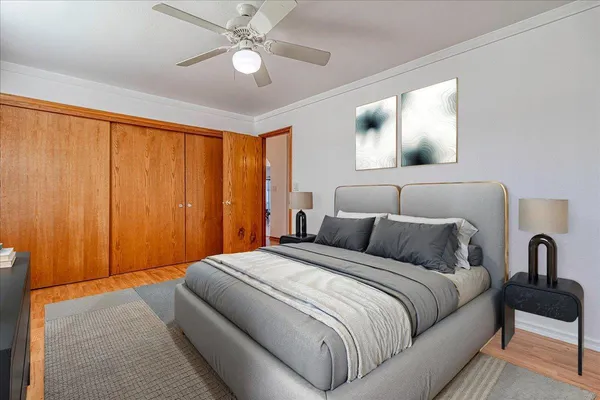 an empty room with wooden floor fan and windows
