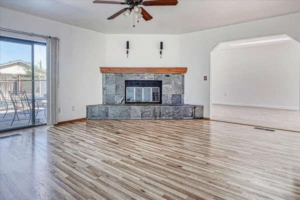a view of a livingroom with wooden floor and a kitchen space