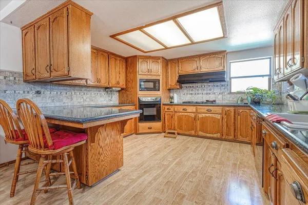 a kitchen with stainless steel appliances granite countertop a stove a sink and a microwave