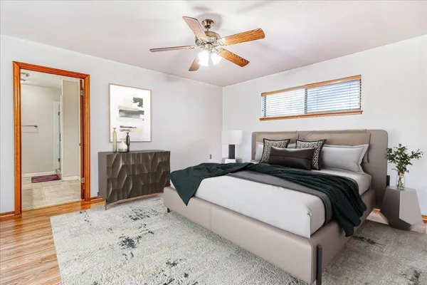 an empty room with wooden floor and ceiling fan