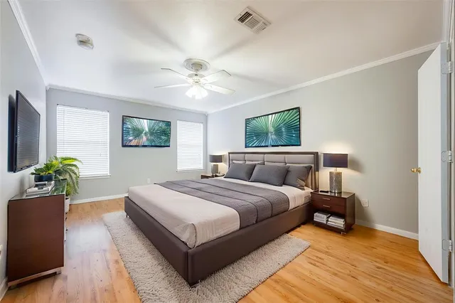 a spacious bedroom with a large bed and a chandelier