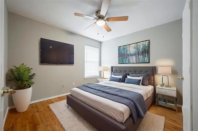 a bedroom with a bed a flat screen tv and a potted plant