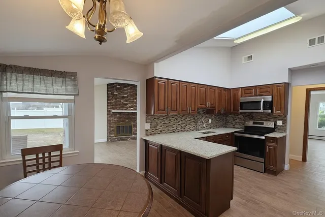 a kitchen with stainless steel appliances granite countertop a stove a sink dishwasher and a refrigerator