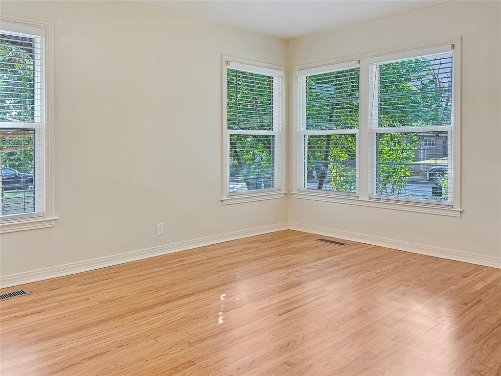 6713 Norma Street Fort Worth, TX 76112 - Photo 11 of 21 a view of an empty room with wooden floor and a window