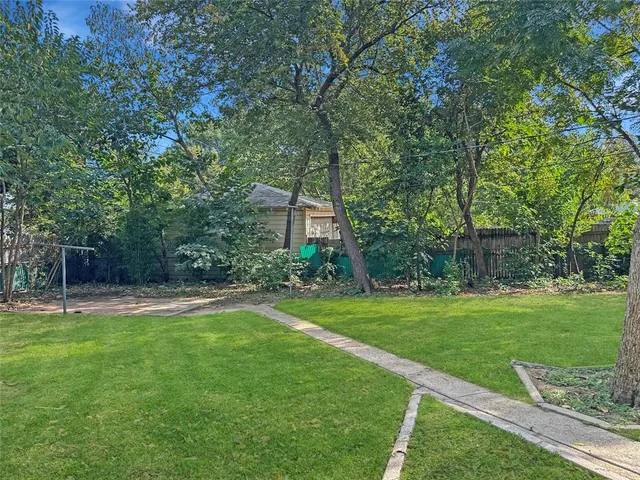 a view of a backyard with large trees