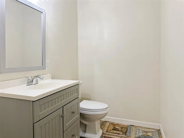 a bathroom with a toilet a sink and mirror