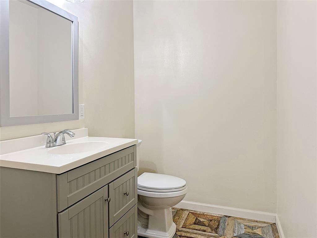 6713 Norma Street Fort Worth, TX 76112 - Photo 6 of 21 a bathroom with a toilet a sink and mirror