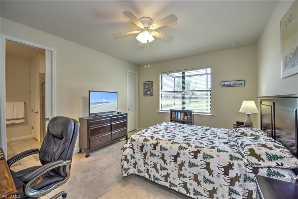 2106 Clementine Street Naples, FL 34120 - Photo 14 of 34 a bedroom with a bed and dresser with mirror