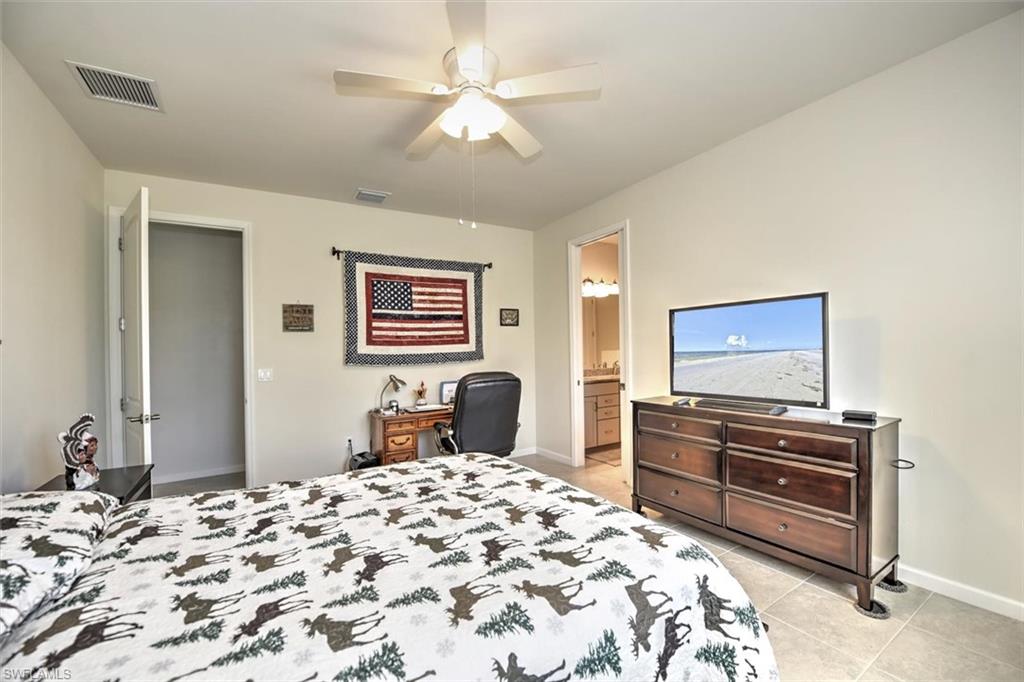 2106 Clementine Street Naples, FL 34120 - Photo 15 of 34 a bedroom with a bed and a dresser