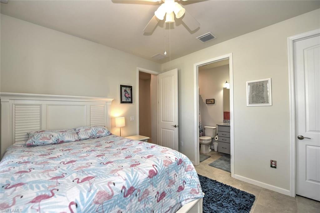 2106 Clementine Street Naples, FL 34120 - Photo 18 of 34 a bedroom with a large bed and a chandelier