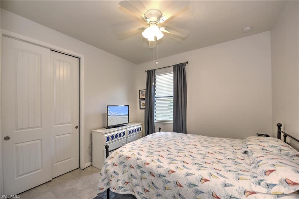 2106 Clementine Street Naples, FL 34120 - Photo 20 of 34 a bedroom with a bed and a chandelier