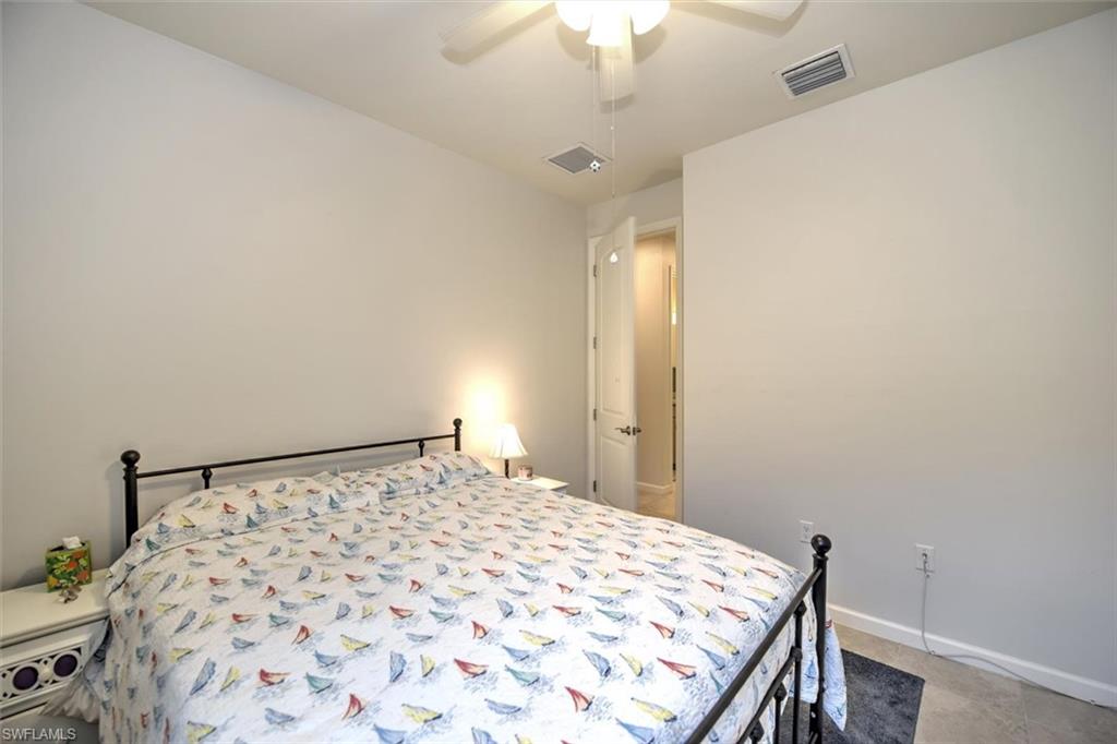 2106 Clementine Street Naples, FL 34120 - Photo 21 of 34 a bedroom with a bed and a dresser