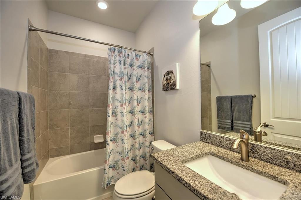 2106 Clementine Street Naples, FL 34120 - Photo 22 of 34 a bathroom with a granite countertop sink toilet mirror and shower