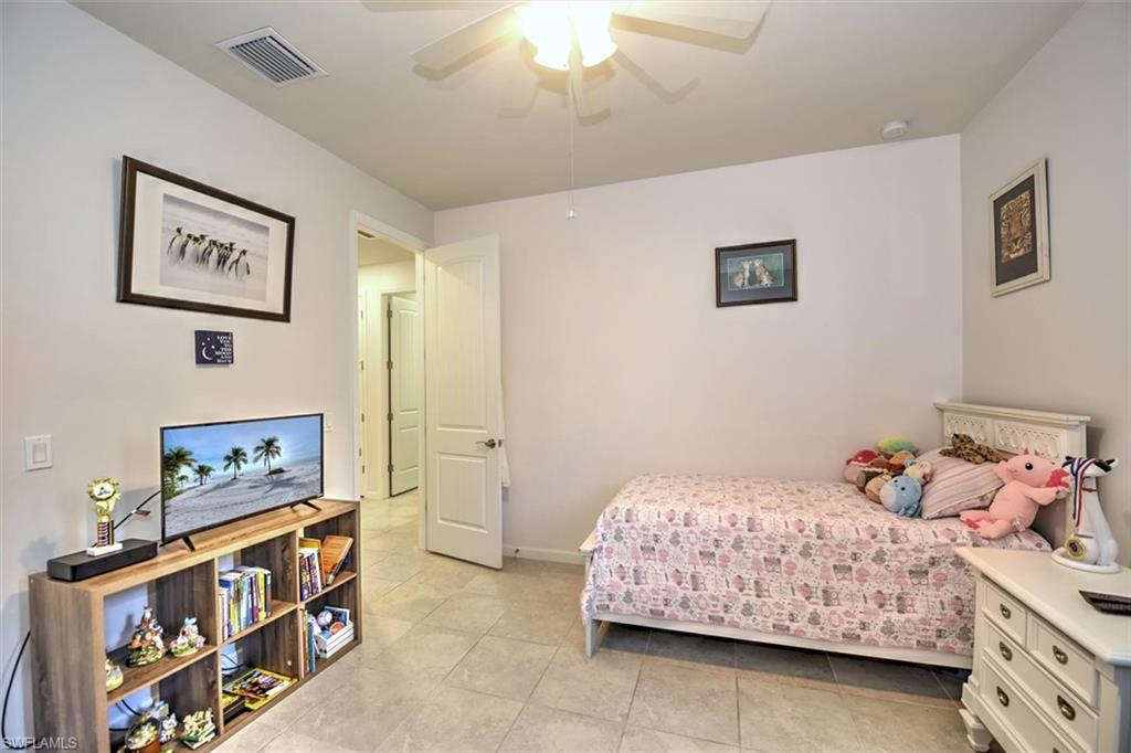 2106 Clementine Street Naples, FL 34120 - Photo 24 of 34 a bedroom with a bed and a baby bed