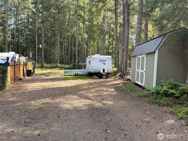 a view of a house with backyard and trees