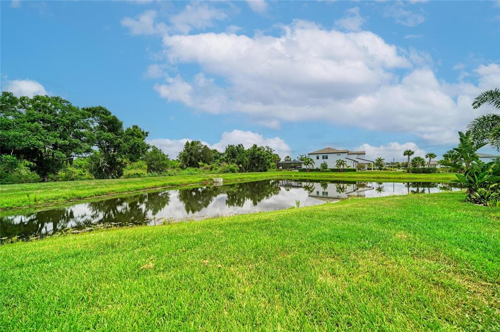 16341 Hidden Oak Loop Lakewood Ranch, FL 34211 - Photo 63 of 76 a view of a lake with a big yard