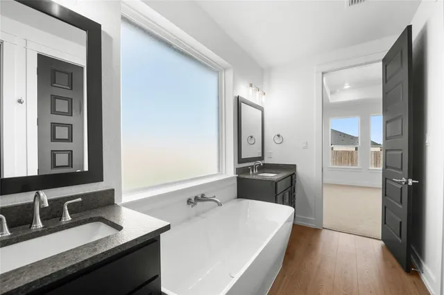 a bathroom with a sink double vanity and a large mirror