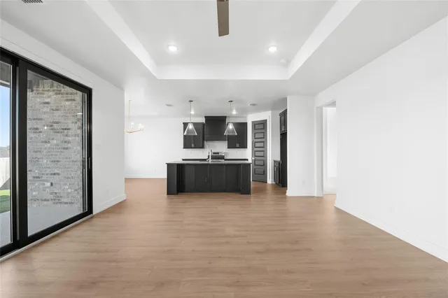 a kitchen with stainless steel appliances granite countertop a sink a stove and a wooden floors
