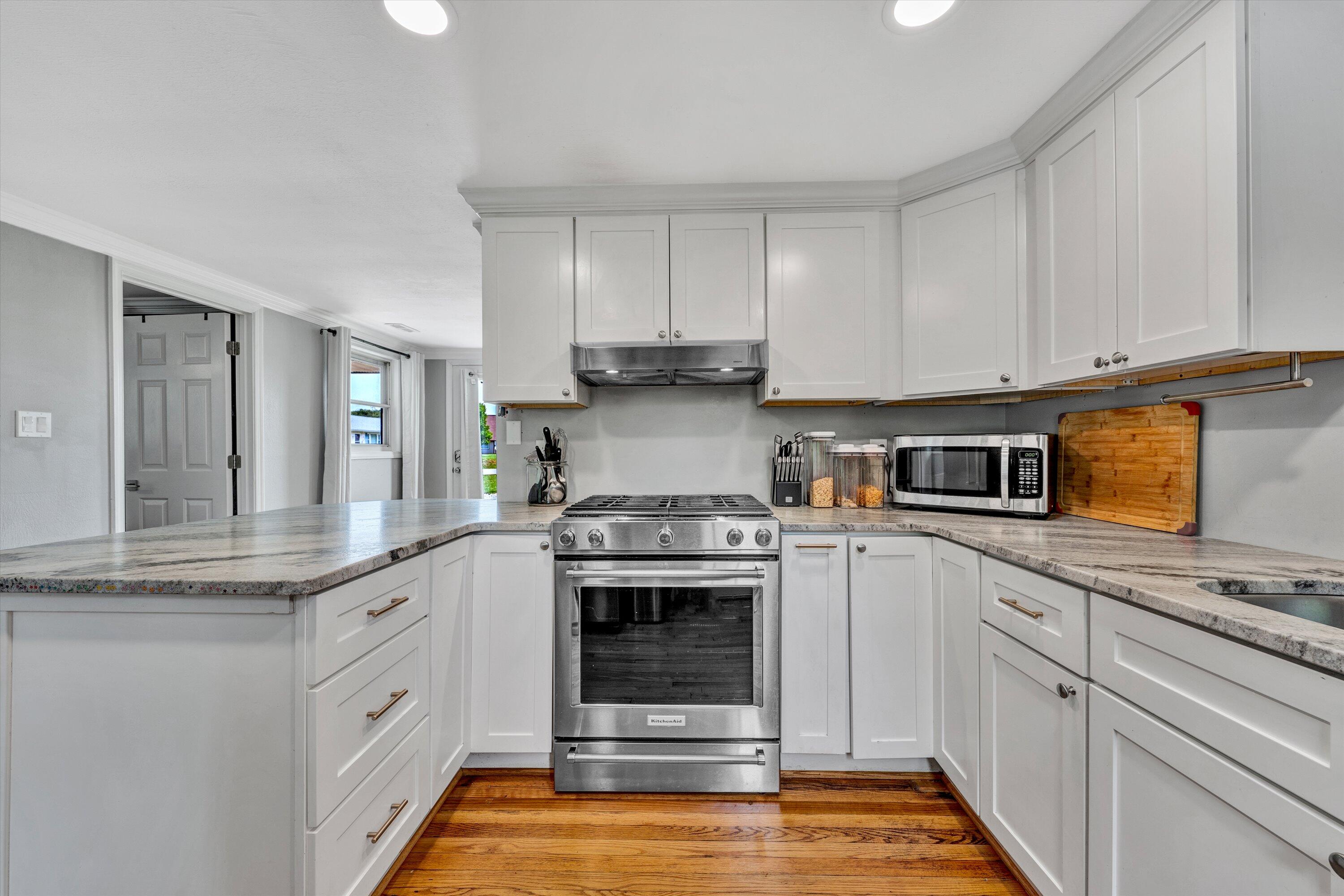 1200 Rock Spring Road Goodview, VA 24095 - Photo 11 of 31 a kitchen with stainless steel appliances granite countertop a stove and white cabinets