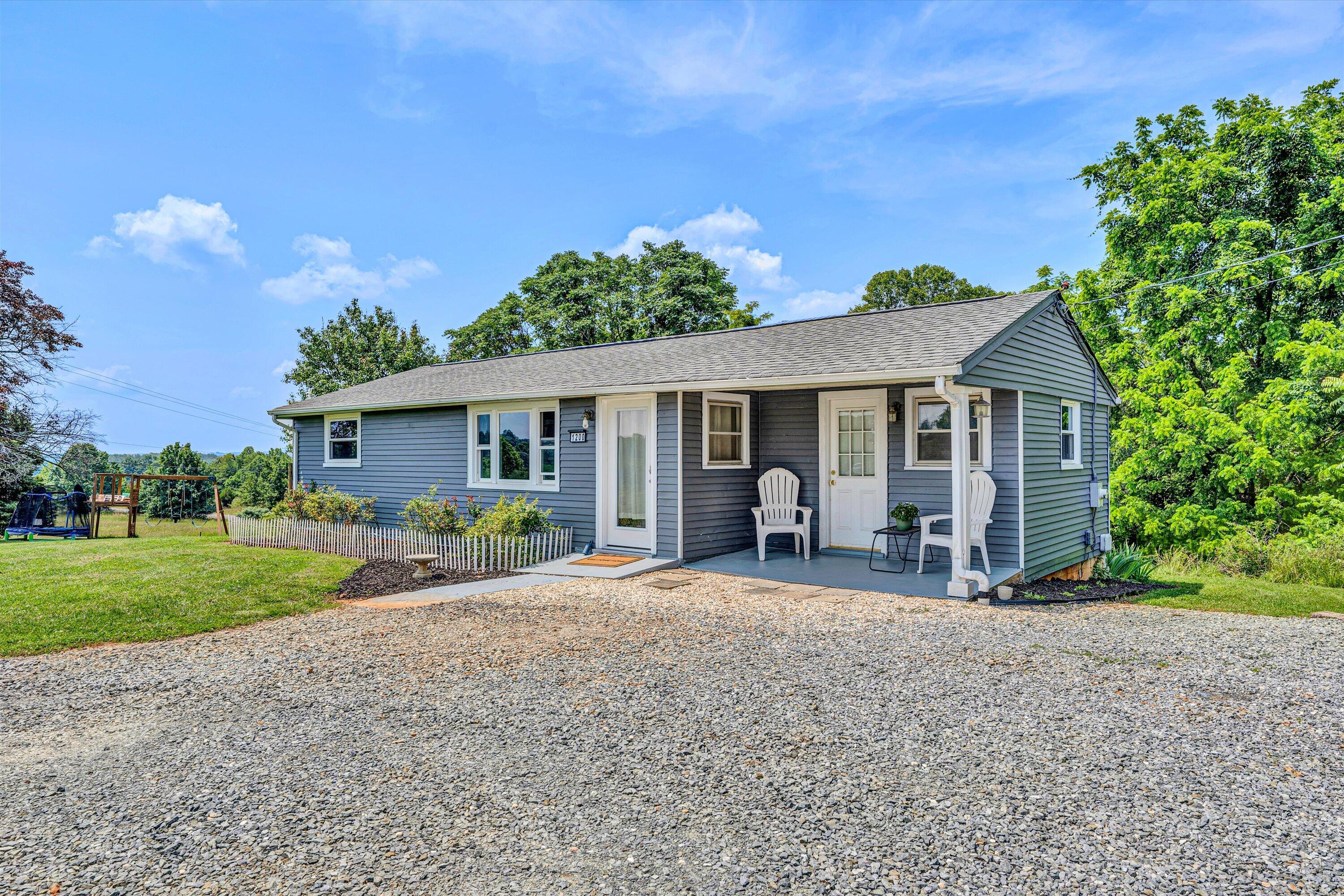 1200 Rock Spring Road Goodview, VA 24095 - Photo 3 of 31 a front view of a house with garden and porch