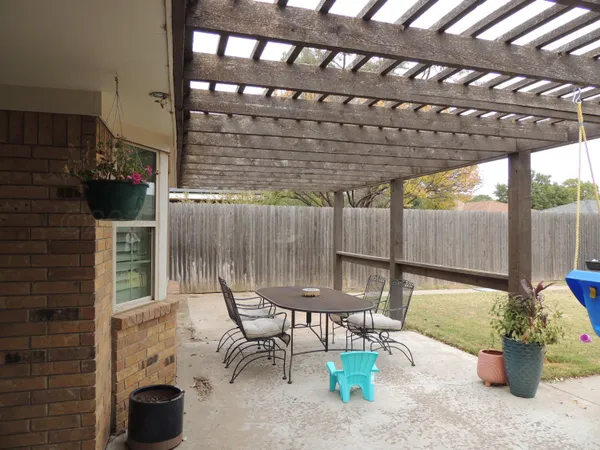 a view of a chairs and table in backyard