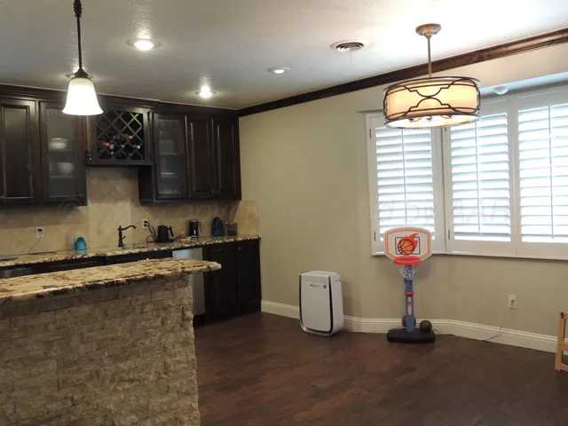 a kitchen with stainless steel appliances granite countertop a sink a stove and a wooden floors